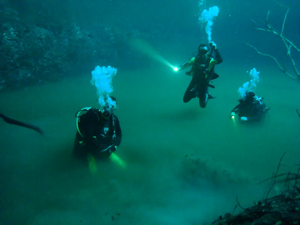 Divers descending through the sulfur layer of Cenote Angelita