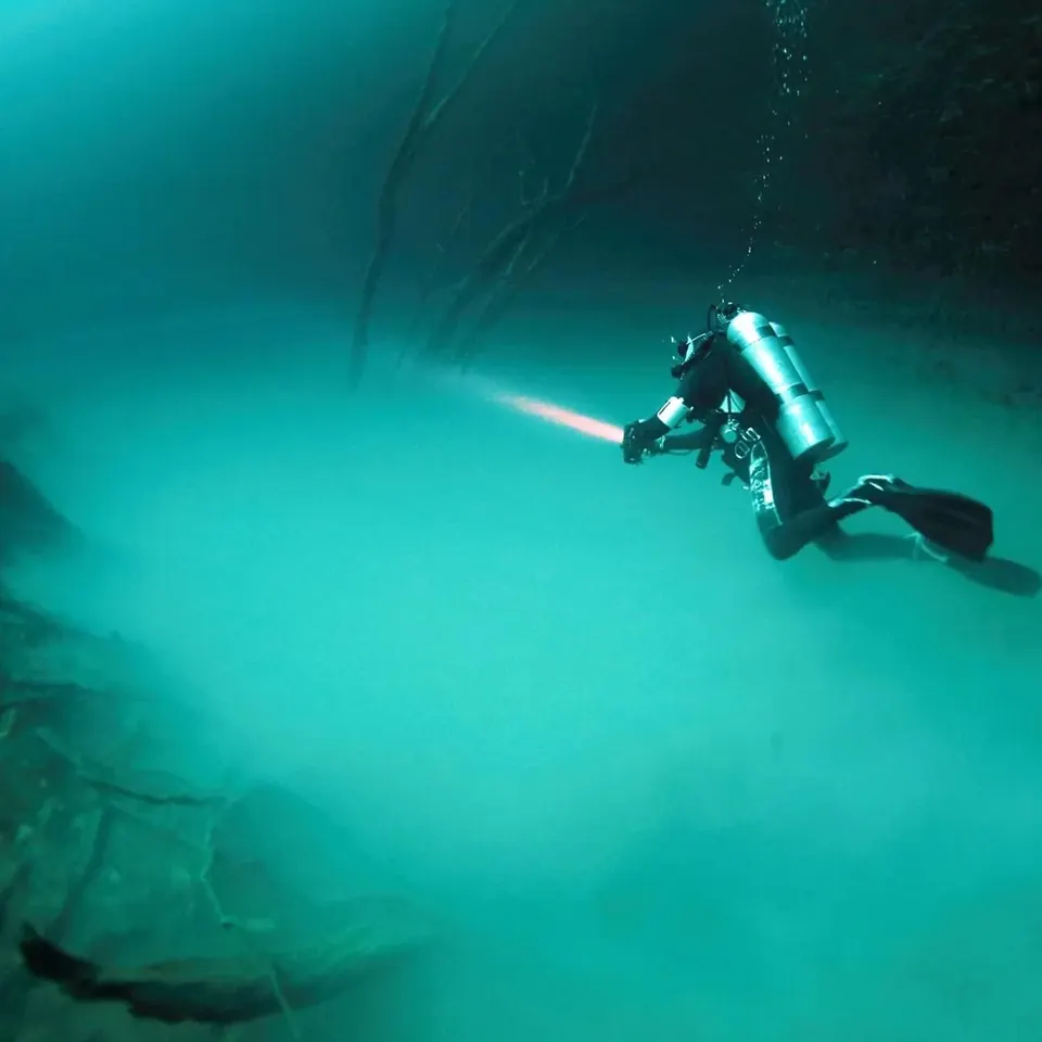 Diver descending into the sulfur cloud of Cenote Angelita