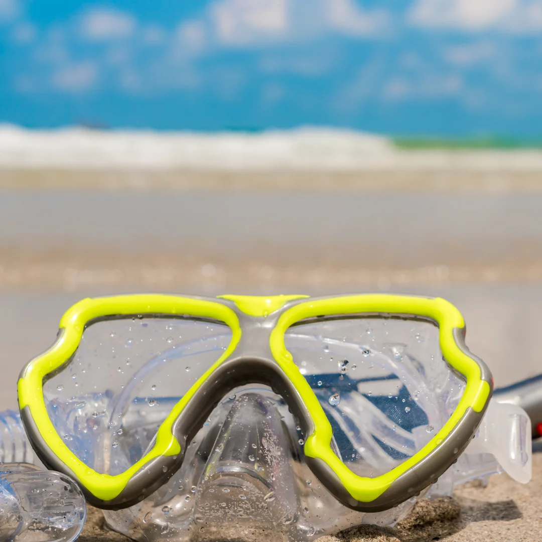A scuba diver swimming alongside a green sea turtle over a coral reef while experiencing scuba diving in Cancun.